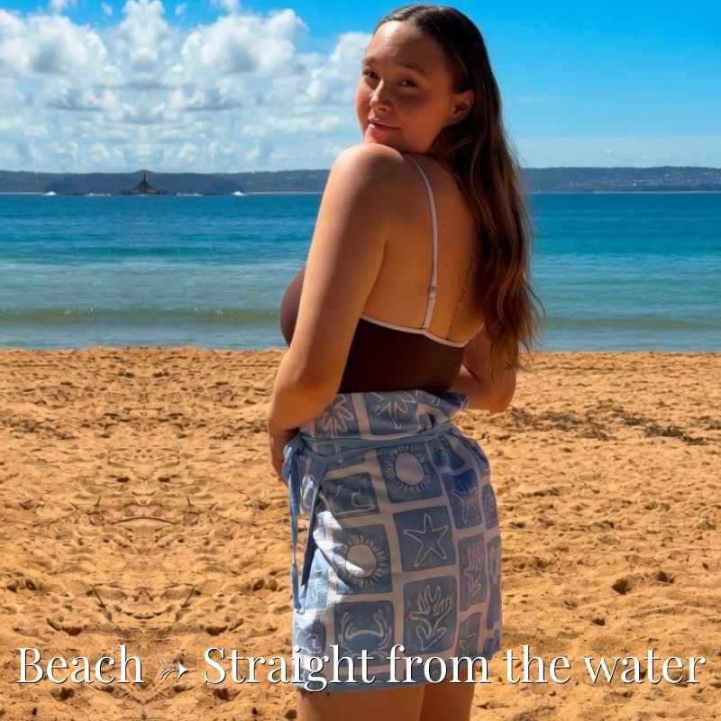Woman on a beach with ocean view and text 'Beach - Straight from the water'.