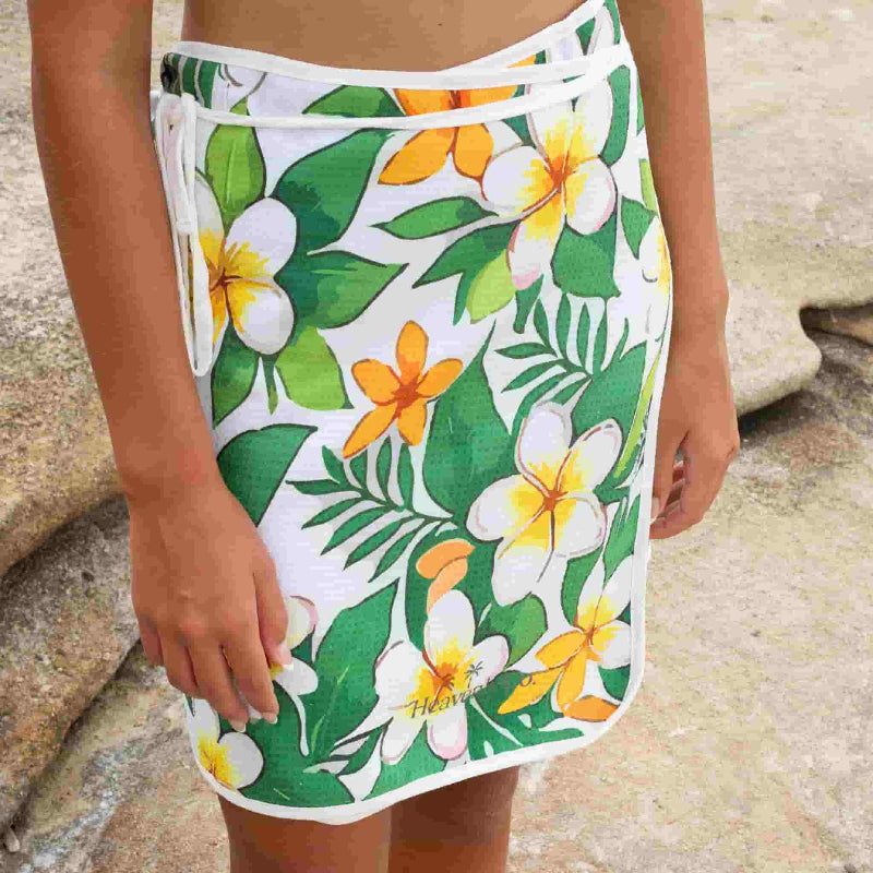 Tropical floral skirt with green leaves and yellow flowers on a white background.