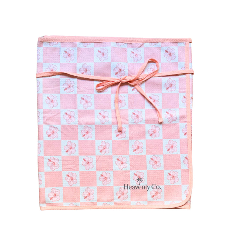 Pink and white checkered blanket with floral patterns, tied with a pink ribbon, on a white background.